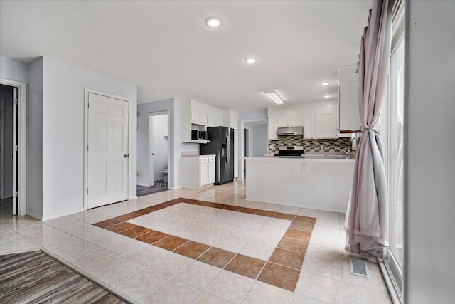 408 Lake Shore Cir, Bloomington, IL 61704 - kitchen with appliances with stainless steel finishes, under cabinet range hood, white cabinets, light tile patterned floors, and recessed lighting