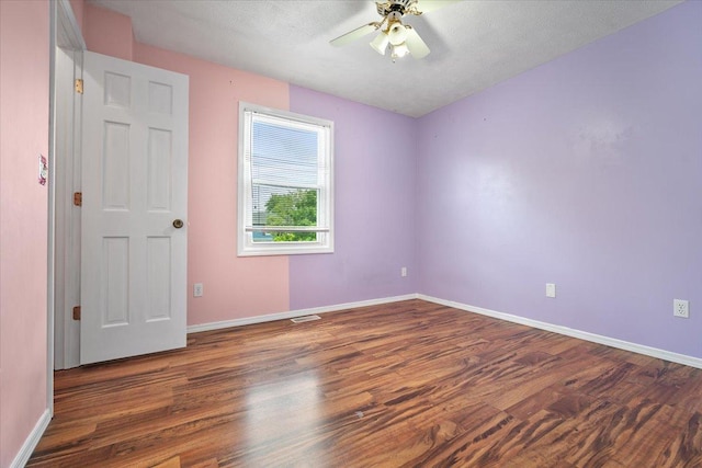 408 Lake Shore Cir, Bloomington, IL 61704 - spare room with wood finished floors, a ceiling fan, and baseboards
