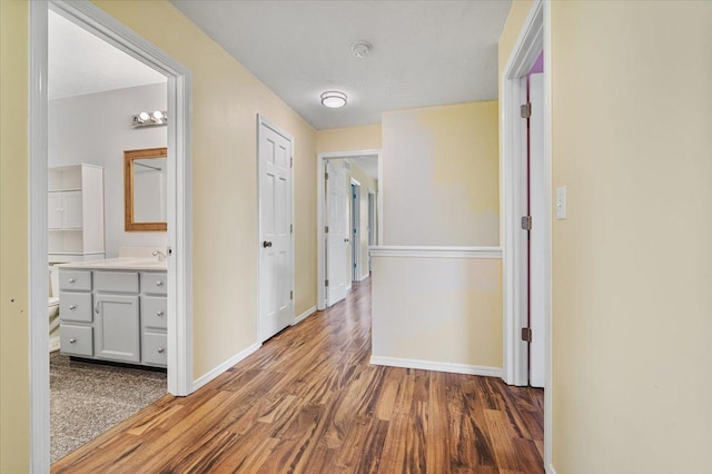 408 Lake Shore Cir, Bloomington, IL 61704 - hallway featuring wood finished floors, baseboards, and a sink