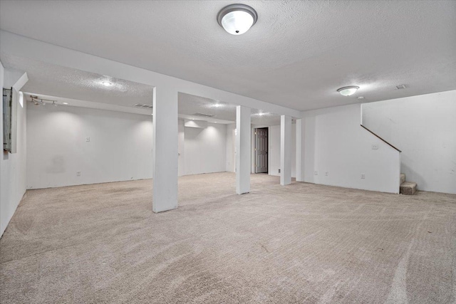 408 Lake Shore Cir, Bloomington, IL 61704 - finished basement with a textured ceiling, stairway, and light colored carpet