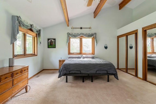 bedroom featuring light carpet, baseboards, ceiling fan, and multiple closets