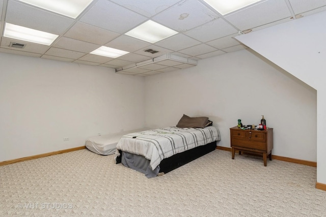 bedroom featuring carpet, baseboards, and a drop ceiling