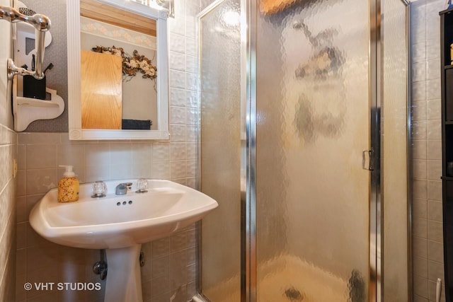 bathroom featuring a shower stall and tile walls
