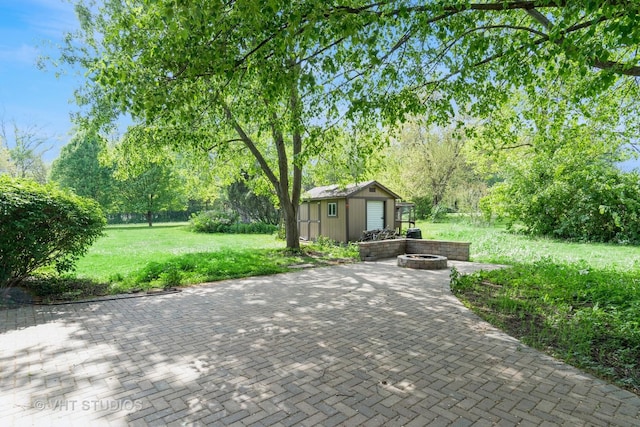 view of patio / terrace featuring a fire pit and an outdoor structure
