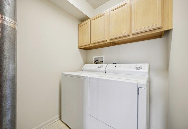 laundry room featuring washing machine and dryer, cabinet space, and baseboards