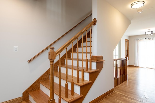 stairs featuring wood finished floors and baseboards