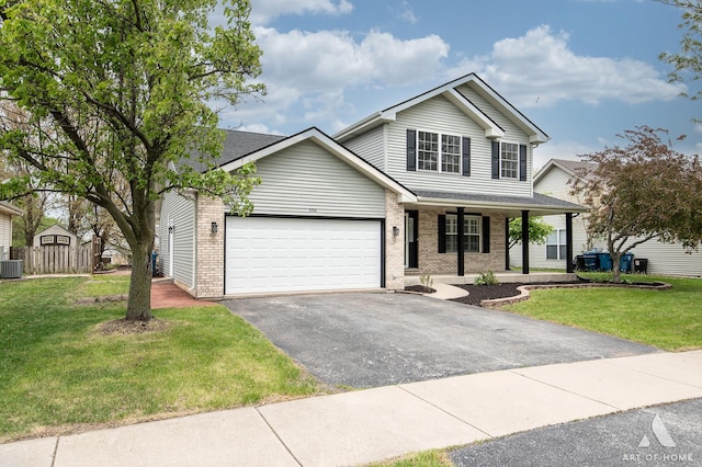 traditional-style home with asphalt driveway, covered porch, an attached garage, brick siding, and a front yard