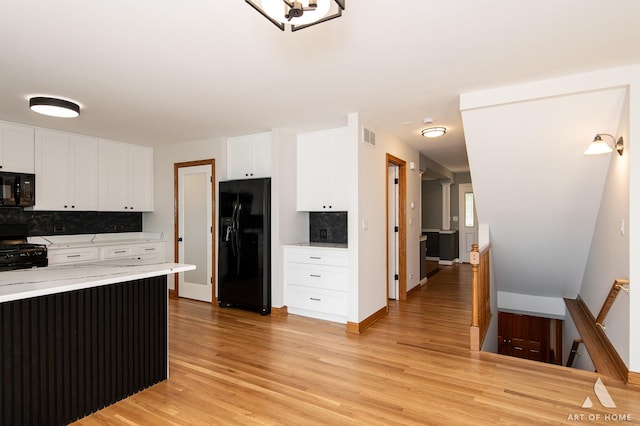 kitchen with black appliances, decorative backsplash, light wood-type flooring, white cabinetry, and light stone counters