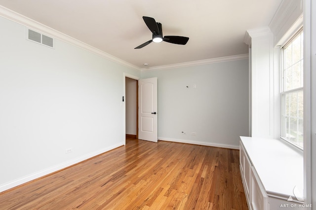 spare room with light wood-style floors, crown molding, baseboards, and a ceiling fan