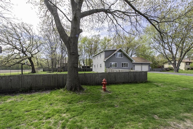 view of yard featuring asphalt driveway and a garage
