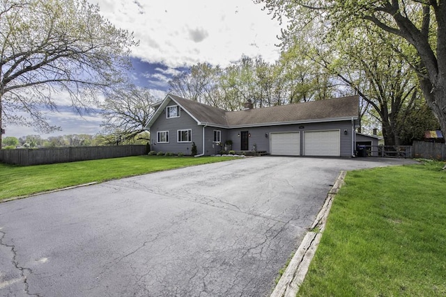 view of front of property featuring driveway, a garage, and a chimney