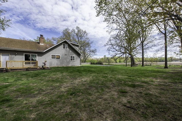 view of green lawn with a wooden deck