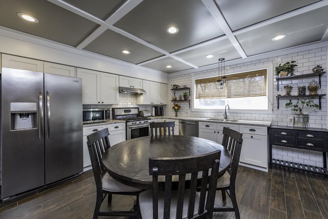 kitchen with stainless steel appliances, open shelves, under cabinet range hood, a sink, and coffered ceiling