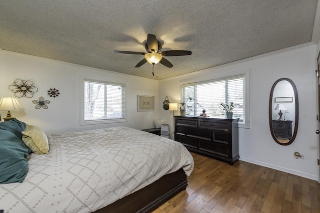bedroom with multiple windows, a textured ceiling, dark wood-type flooring, ornamental molding, and ceiling fan