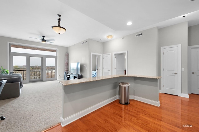 kitchen featuring ceiling fan, light wood-style flooring, baseboards, and light stone countertops