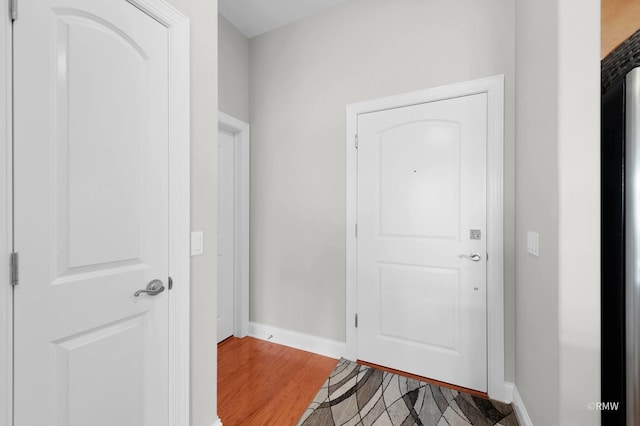 entryway with baseboards and light wood-style flooring