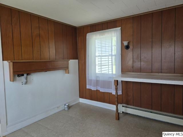 301 N St, Augusta, IL 62311 - clothes washing area featuring a baseboard radiator, tile patterned floors, baseboards, and wood walls