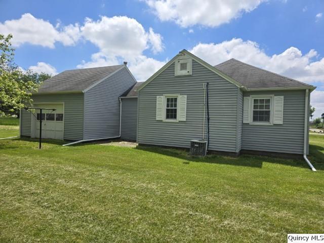301 N St, Augusta, IL 62311 - rear view of property featuring a yard, an outdoor structure, and a shingled roof