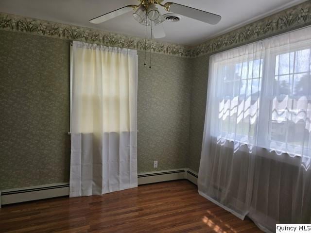 301 N St, Augusta, IL 62311 - empty room featuring a baseboard heating unit, wood finished floors, ceiling fan, and wallpapered walls
