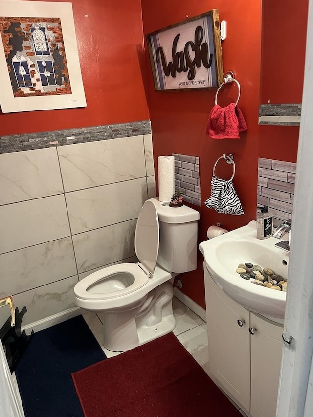 18650 Golfview Dr, Hazel Crest, IL 60429 - half bathroom featuring tile walls, toilet, vanity, and a wainscoted wall