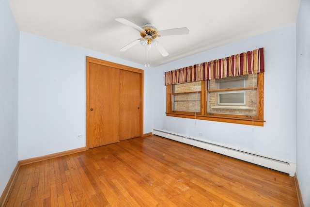 3707 Clarence Ave, Berwyn, IL 60402 - unfurnished bedroom featuring baseboard heating, wood-type flooring, a closet, and baseboards