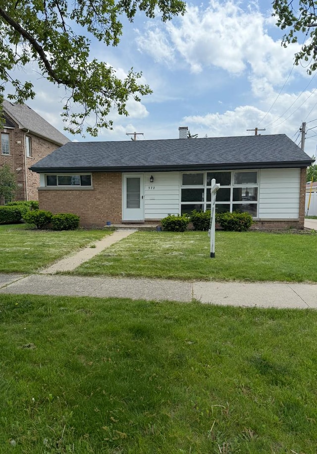 ranch-style house with brick siding and a front lawn