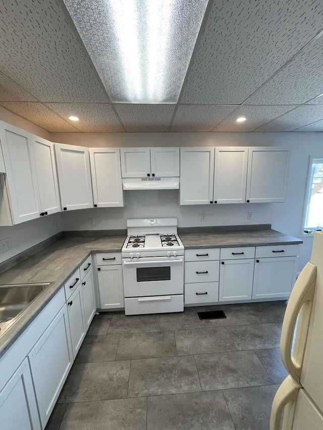 617 W Madison St, Pontiac, IL 61764 - kitchen featuring white gas range, under cabinet range hood, a drop ceiling, white cabinetry, and a sink