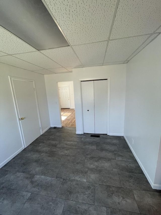 617 W Madison St, Pontiac, IL 61764 - unfurnished bedroom featuring baseboards, a drop ceiling, and a closet