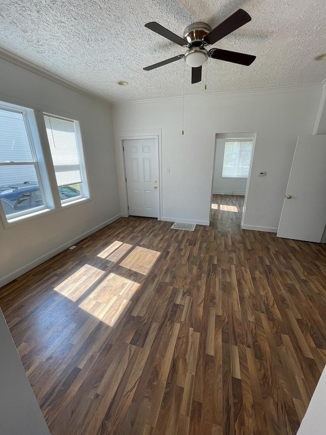 617 W Madison St, Pontiac, IL 61764 - unfurnished living room with a textured ceiling, dark wood finished floors, plenty of natural light, a ceiling fan, and baseboards