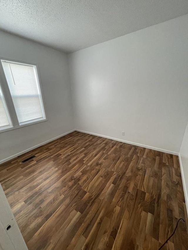 617 W Madison St, Pontiac, IL 61764 - empty room with dark wood-type flooring, baseboards, and a textured ceiling