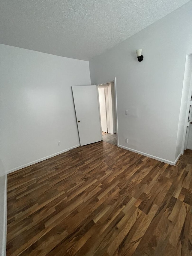 617 W Madison St, Pontiac, IL 61764 - spare room with dark wood finished floors, a textured ceiling, and baseboards