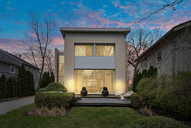 824 Humboldt Ave, Winnetka, IL 60093 - back of house at dusk with a wooden deck and a lawn