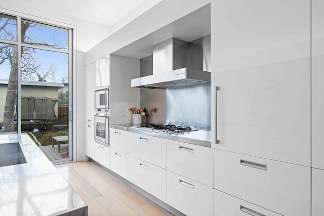 824 Humboldt Ave, Winnetka, IL 60093 - kitchen featuring white appliances, wall chimney range hood, modern cabinets, and white cabinets