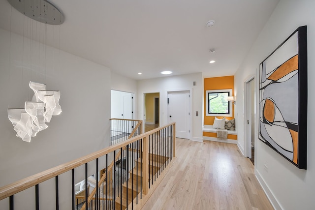 hall featuring an upstairs landing, light wood-style floors, recessed lighting, and baseboards