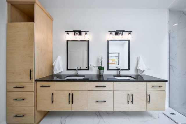 full bath with marble finish floors, double vanity, and a shower stall