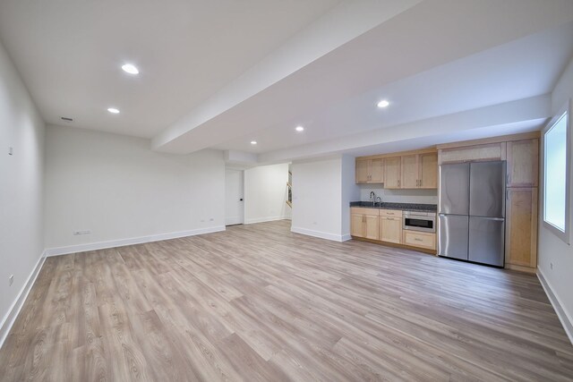 unfurnished living room featuring light wood-style flooring, recessed lighting, baseboards, and a sink