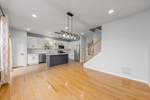 4216 Drexel Ave, Aurora, IL 60504 - kitchen with stainless steel appliances, light wood-style flooring, light countertops, white cabinets, and a sink