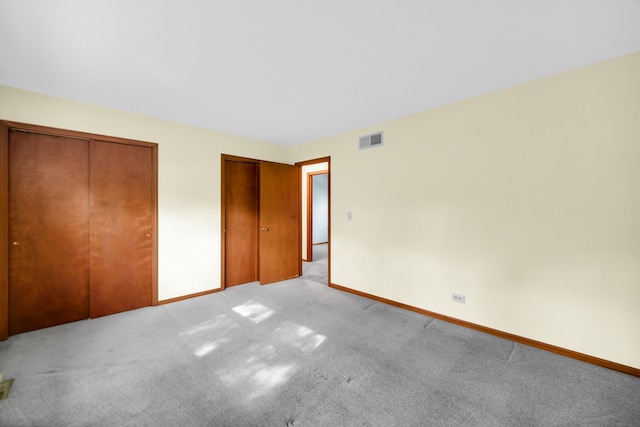 588 Renee Dr, South Elgin, IL 60177 - unfurnished bedroom featuring multiple closets, light colored carpet, and baseboards