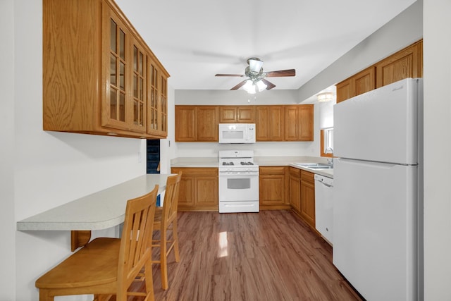 588 Renee Dr, South Elgin, IL 60177 - kitchen featuring white appliances, wood finished floors, a ceiling fan, glass insert cabinets, and light countertops