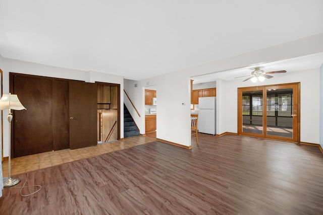 588 Renee Dr, South Elgin, IL 60177 - unfurnished living room featuring wood finished floors, stairs, ceiling fan, and baseboards