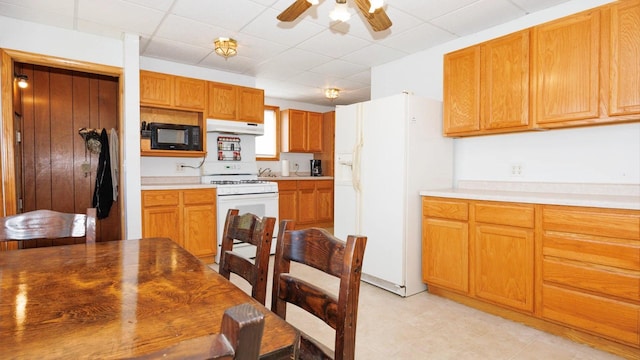 kitchen with white appliances, under cabinet range hood, a ceiling fan, a paneled ceiling, and light countertops