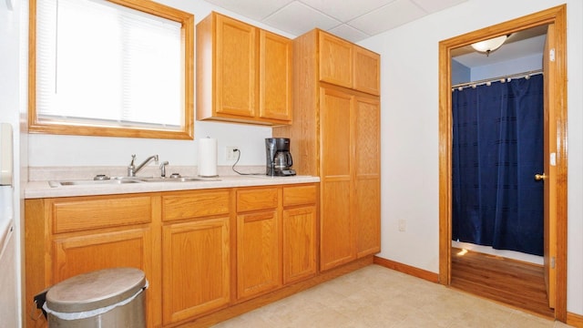 kitchen featuring a sink, light countertops, and baseboards