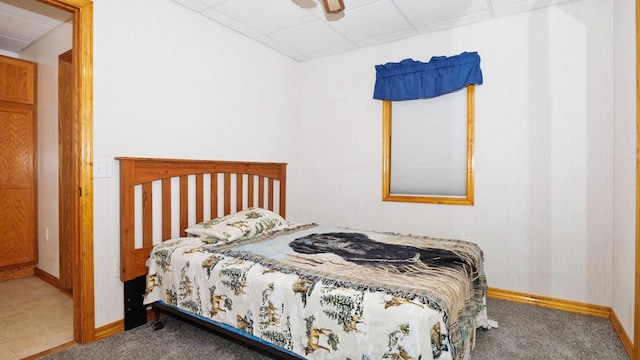 bedroom with a paneled ceiling, baseboards, and carpet floors