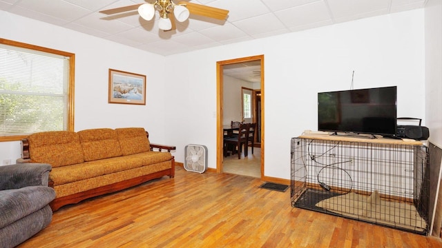 living area with wood finished floors, ceiling fan, and baseboards