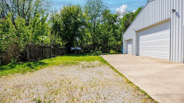 view of yard featuring fence and a garage