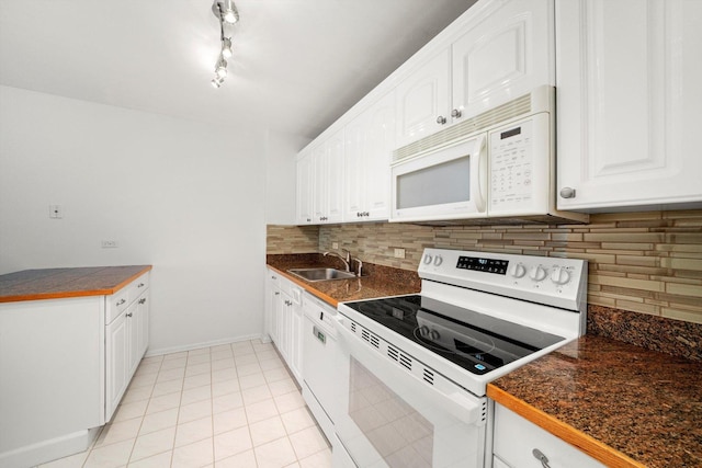 kitchen with white appliances, a sink, decorative backsplash, white cabinetry, and baseboards