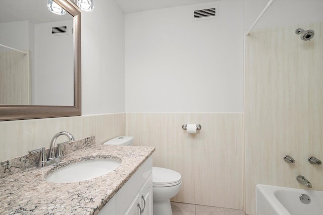 bathroom with a wainscoted wall, vanity, toilet, shower / bathtub combination, and tile patterned flooring