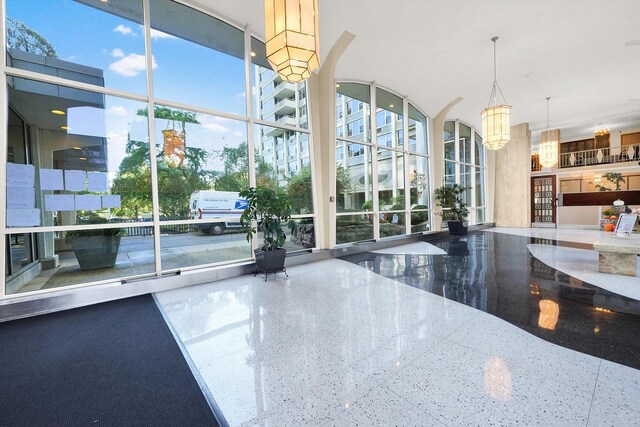 community lobby with floor to ceiling windows and a towering ceiling