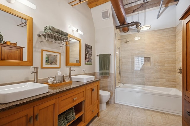 bathroom featuring toilet, bathtub / shower combination, and double vanity