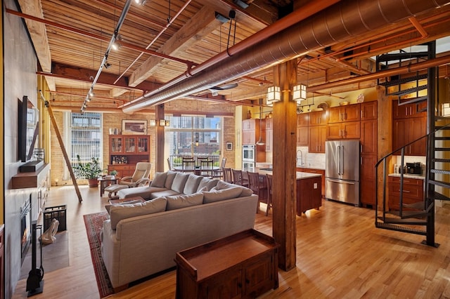 living area with light wood-type flooring, wood ceiling, beam ceiling, and track lighting